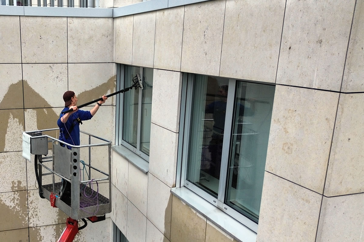 Glasreinigung an einer Fassade, Reinigungsdienstleistung Gebäudereinigung - Gebäudereinigung Kubau bietet professionelle Reinigungsdienstleistungen im Westerwald, Koblenz, Rhein-Sieg-Kreis und Umgebung. Wir sind Ihr zuverlässiger Partner für Gebäudereinigung, Glasreinigung, Unterhaltsreinigung, Fassadenreinigung, Bauschlussreinigung, Teppichbodenreinigung, Winterdienst und Hausmeisterdienst Fensterreinigung einer Fassade mit Reinigungsstange